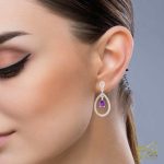 گوشواره طلا با نگین بنفش امتیست و برلیان درخشان روی گوش مدل